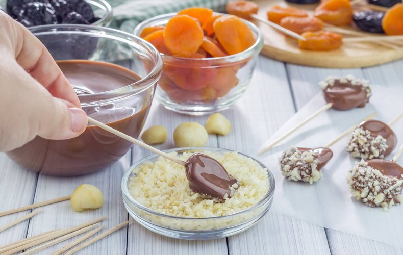 Piruletas de fruta y chocolate con avellana troceada